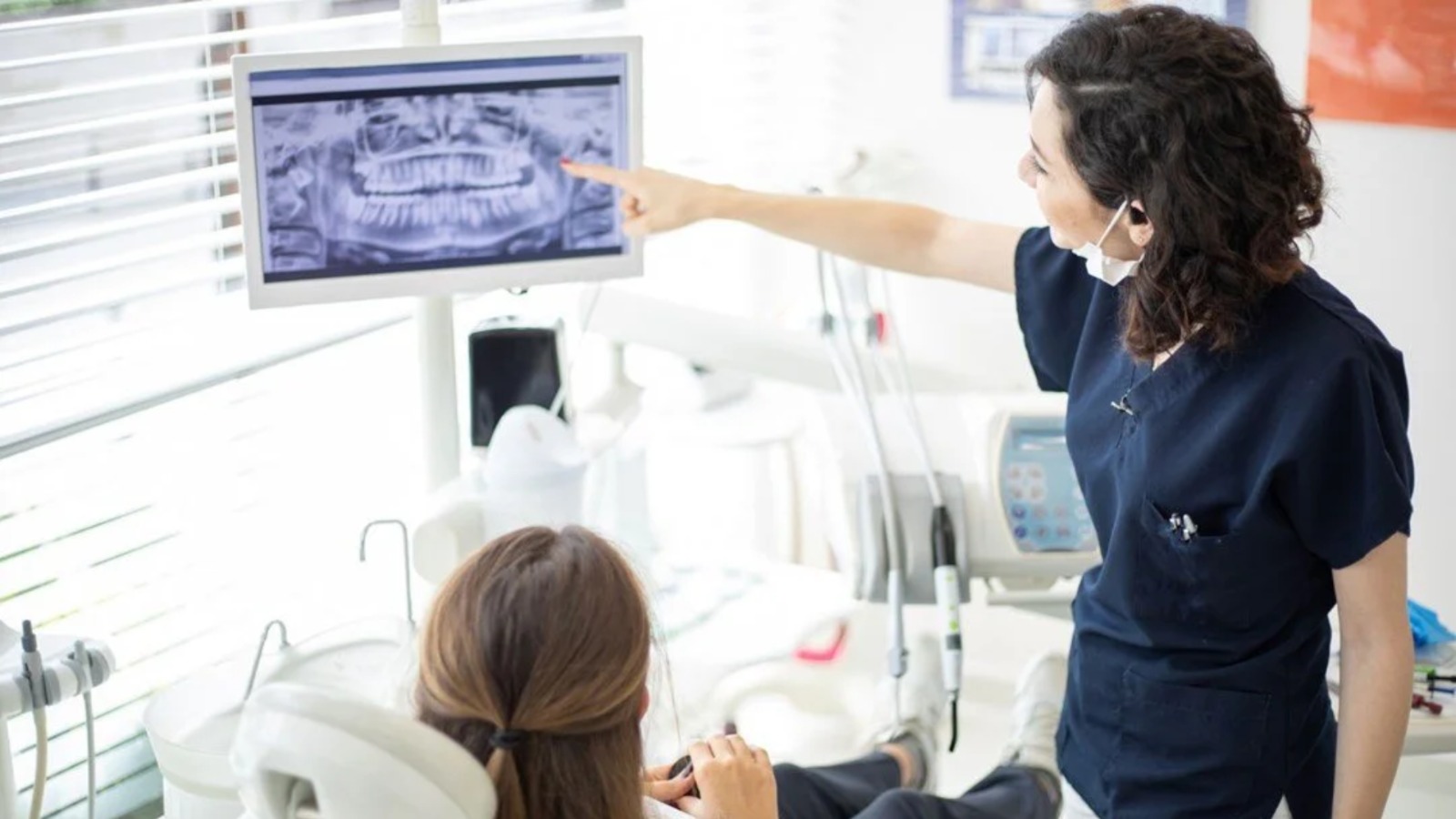 Dentist performing an apicoectomy procedure to remove infected tissue from the tip of a tooth root.