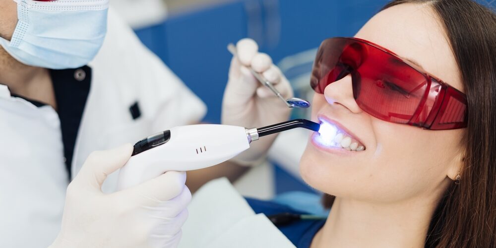 Dentist performing laser dentistry treatment for painless dental procedure