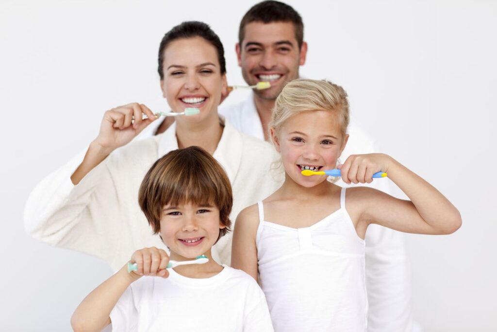 Happy family brushing teeth and maintaining oral hygiene during summer