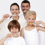 Happy family brushing teeth and maintaining oral hygiene during summer